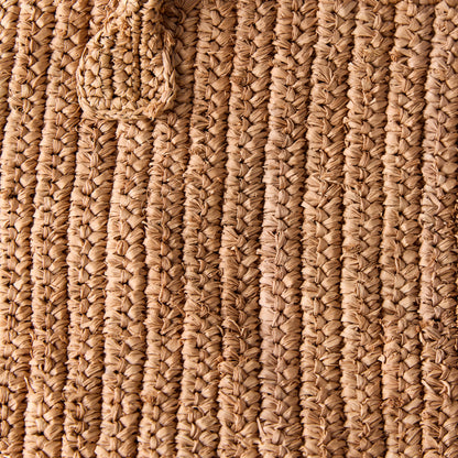 Close-up of a Madagascar Packable Raffia Tote Bag, showing its natural tea-dyed, crocheted raffia texture.