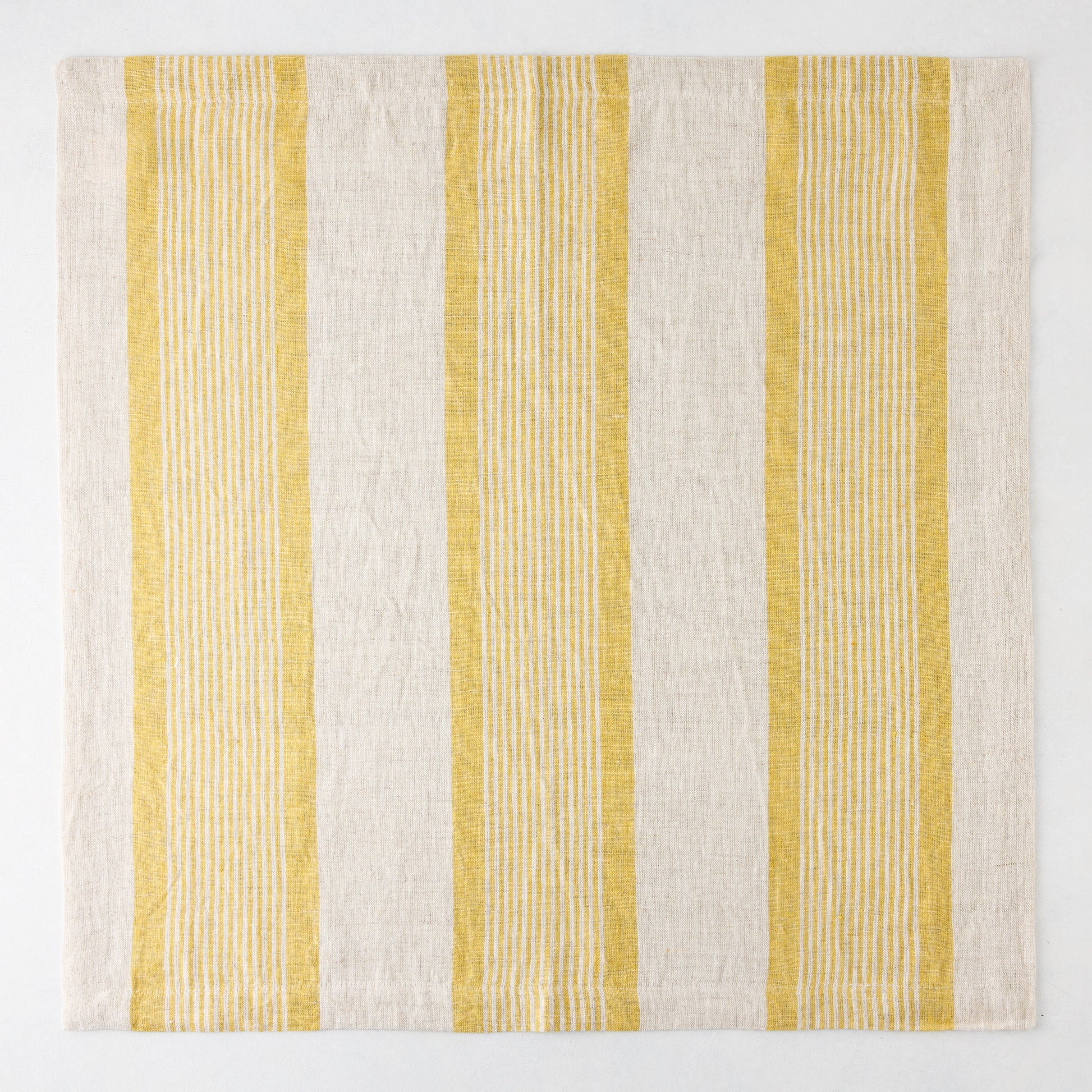Madras Marigold and Natural Stripe Cotton Napkin, 22" square, with yellow stripes on a beige base.