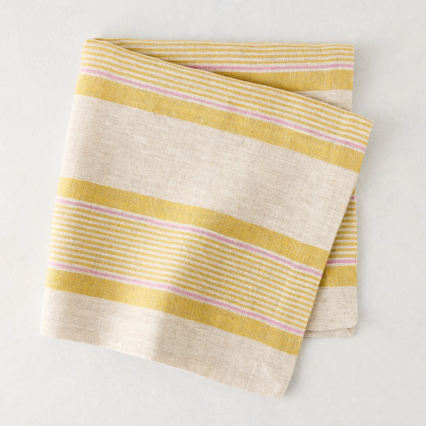 Folded Madras Marigold, Pink, and Natural Stripe Cotton Napkin, 22" square.