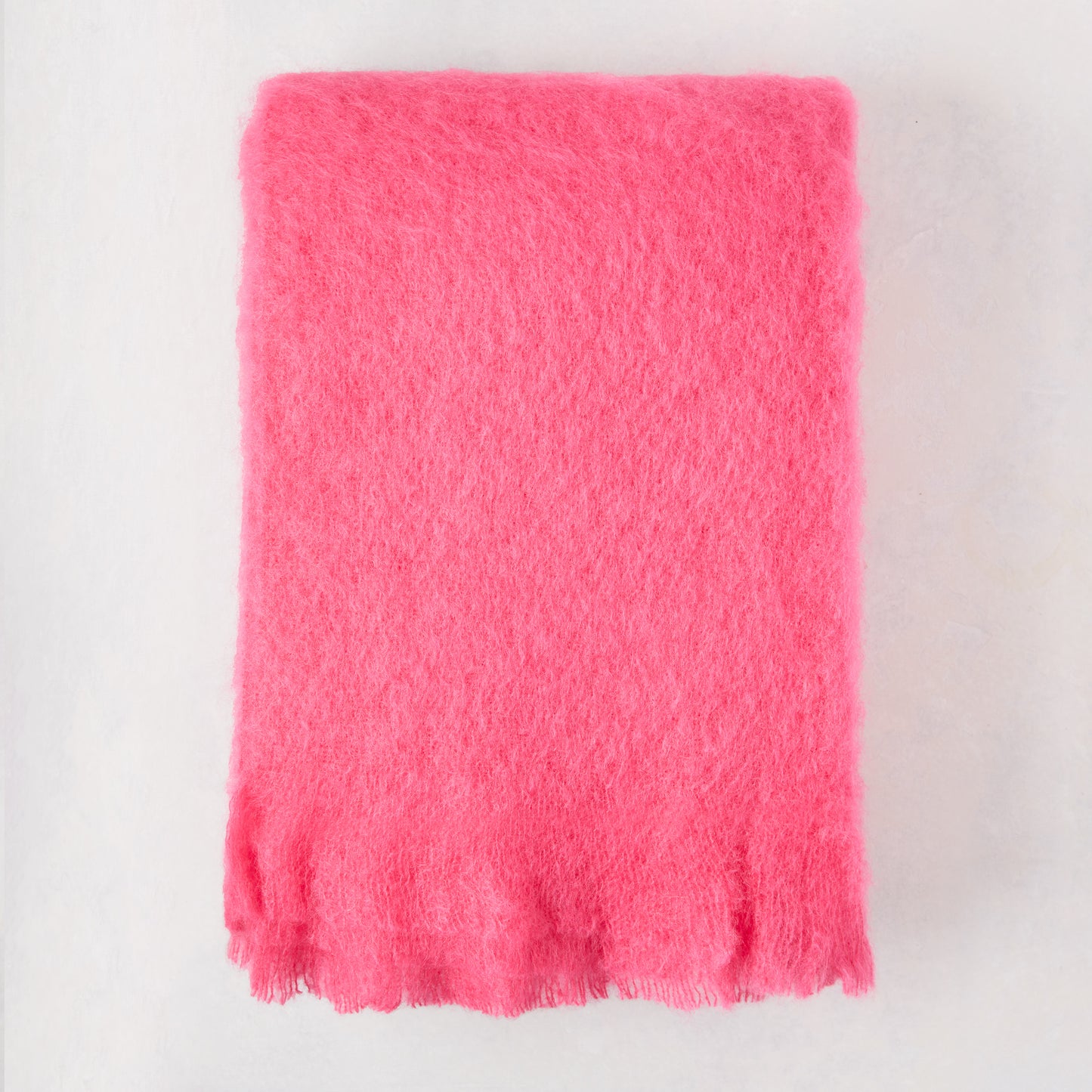 Magenta pink solid mohair throw, 72"L x 51"W, with fringed edges.
