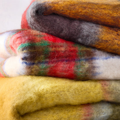 Handwoven Mantas Ezcaray mohair throw in a multicolored plaid pattern of yellow, red, blue, green, and brown.