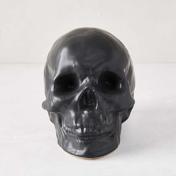 Matte black ceramic Halloween skull, 5.5”H x 7”W, with realistic features.