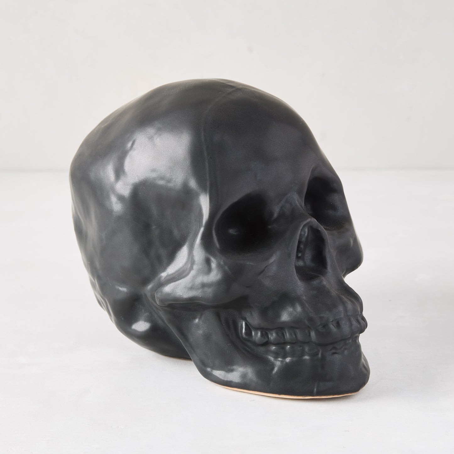 Matte black ceramic Halloween skull, 5.5"H x 7"W, with realistic details.