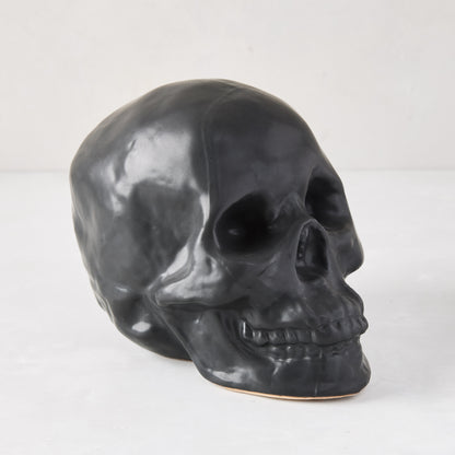 Matte black ceramic Halloween skull, 5.5"H x 7"W, with realistic details.
