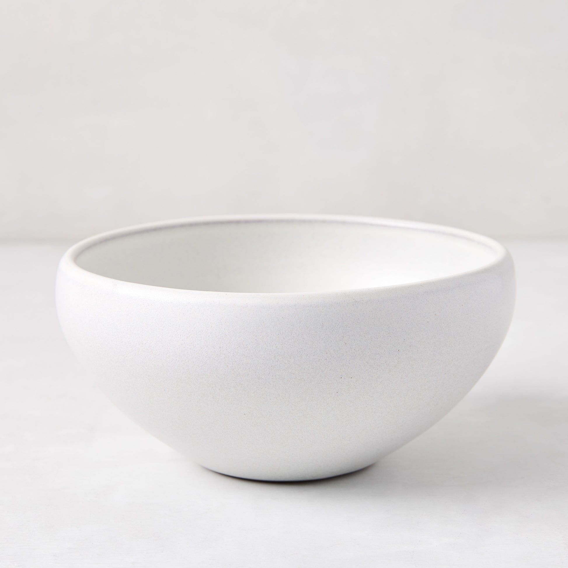 Matte white stoneware bowl with subtle grey speckles, handcrafted in Portugal.