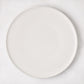 Matte white stoneware dinner plate with subtle grey speckles.