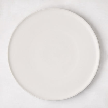 Matte white stoneware dinner plate with subtle grey speckles.