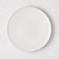 Matte white stoneware salad plate with a smooth glaze and subtle grey speckles.