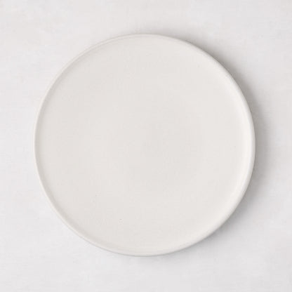Matte white stoneware salad plate with a smooth glaze and subtle grey speckles.