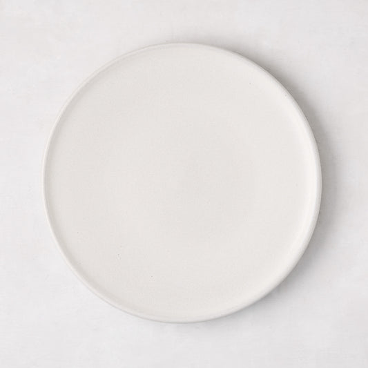 Matte white stoneware salad plate with a smooth glaze and subtle grey speckles.
