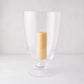 Mayfair Medium Glass Hurricane, clear glass with decorative base, holding a lit cream pillar candle.