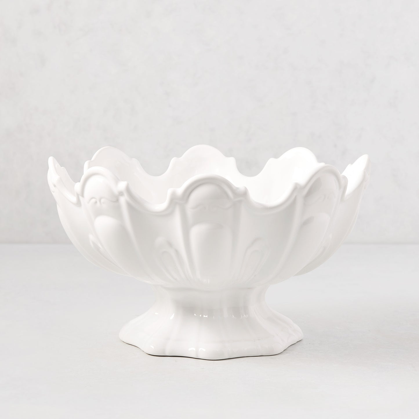 White ceramic scallop serve bowl with decorative base.