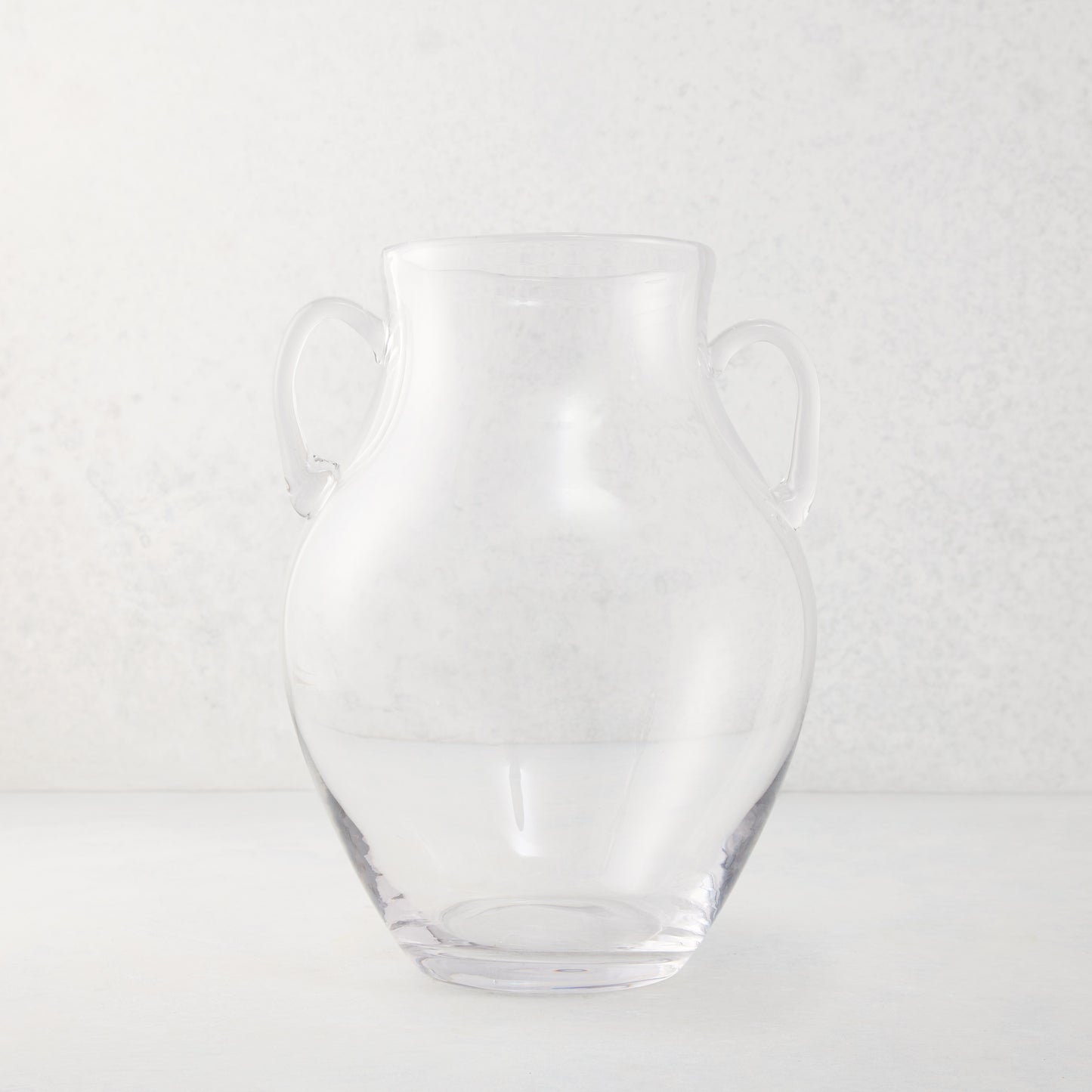 Medium clear recycled glass confit vase with organic curves and decorative handles.