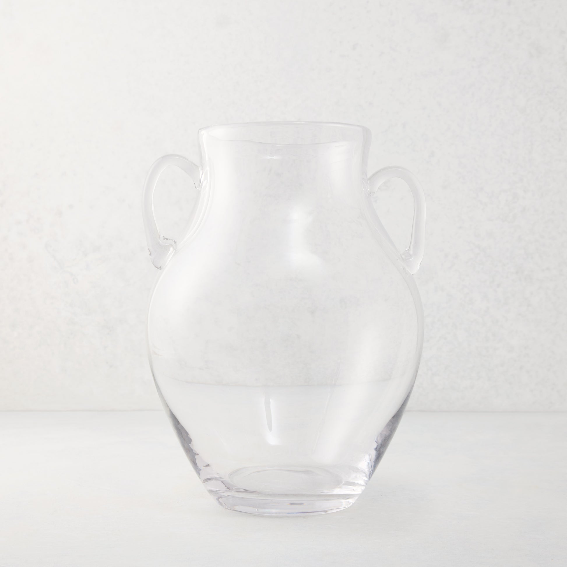 Medium clear recycled glass confit vase with organic curves and decorative handles.