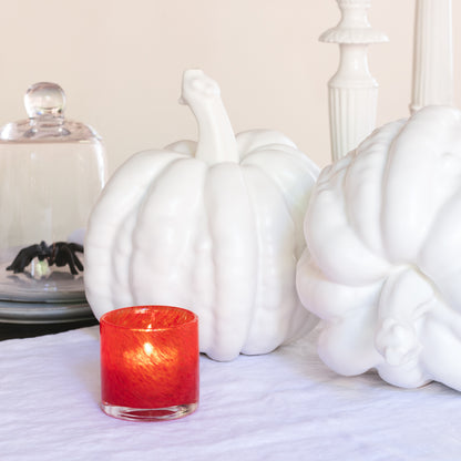 Small matte white ceramic pumpkin, 8.5"H x 9"W, with a red candle and spider decor.