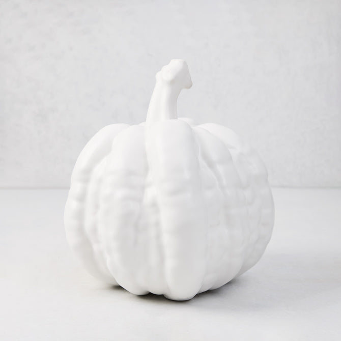 Small matte white ceramic pumpkin, 8.5"H x 9"W, with ribbed texture and short stem.