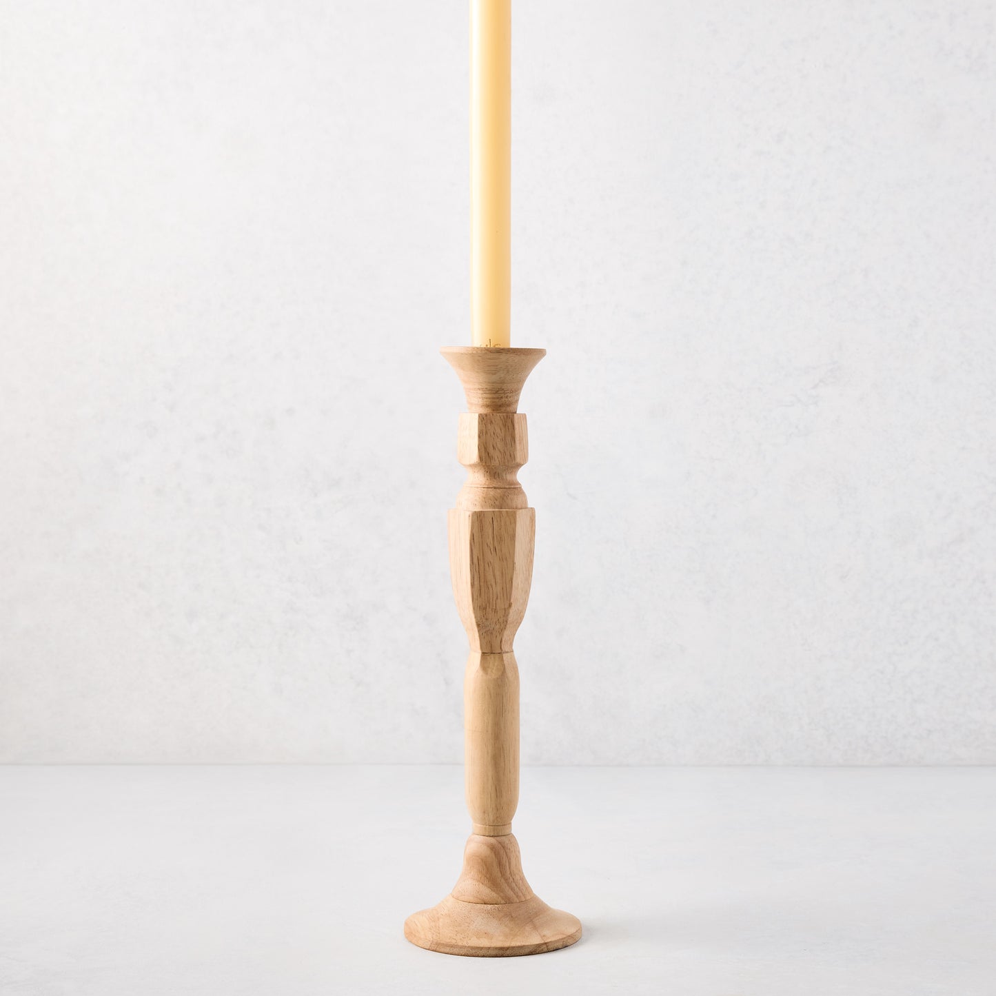 Medium natural beechwood Georgian candlestick with a cream taper candle.