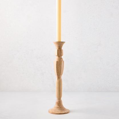 Medium natural beechwood Georgian candlestick with a cream taper candle.