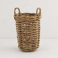 Medium round basket made of natural sandblasted rattan with two side handles on a white background.