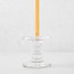 Medium clear glass taper candleholder with ridges, holding a beige taper candle.