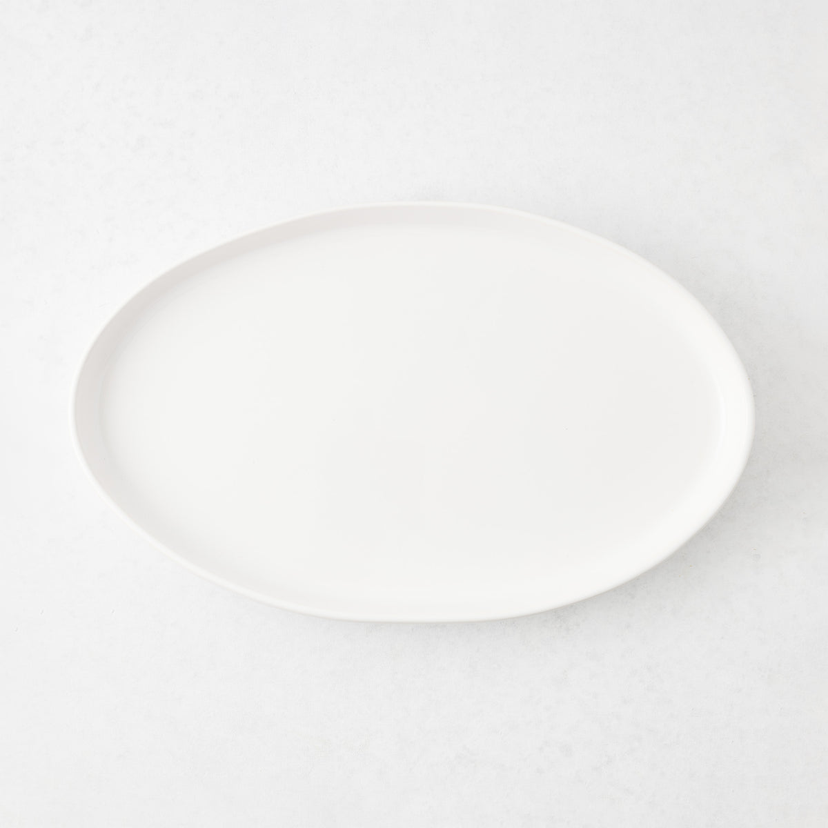Medium oval white stoneware serving platter with a minimalist design, 15 inches long, handmade in Portugal.