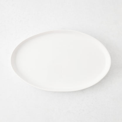 Medium oval white stoneware serving platter with a minimalist design, 15 inches long, handmade in Portugal.