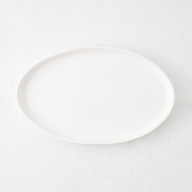 Medium oval white stoneware serving platter with a minimalist design, 15 inches long, handmade in Portugal.