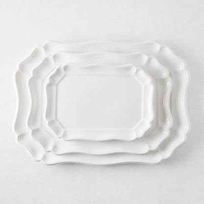 Three nested white ceramic Torcello serve platters with scalloped edges and a glossy finish on a white background.