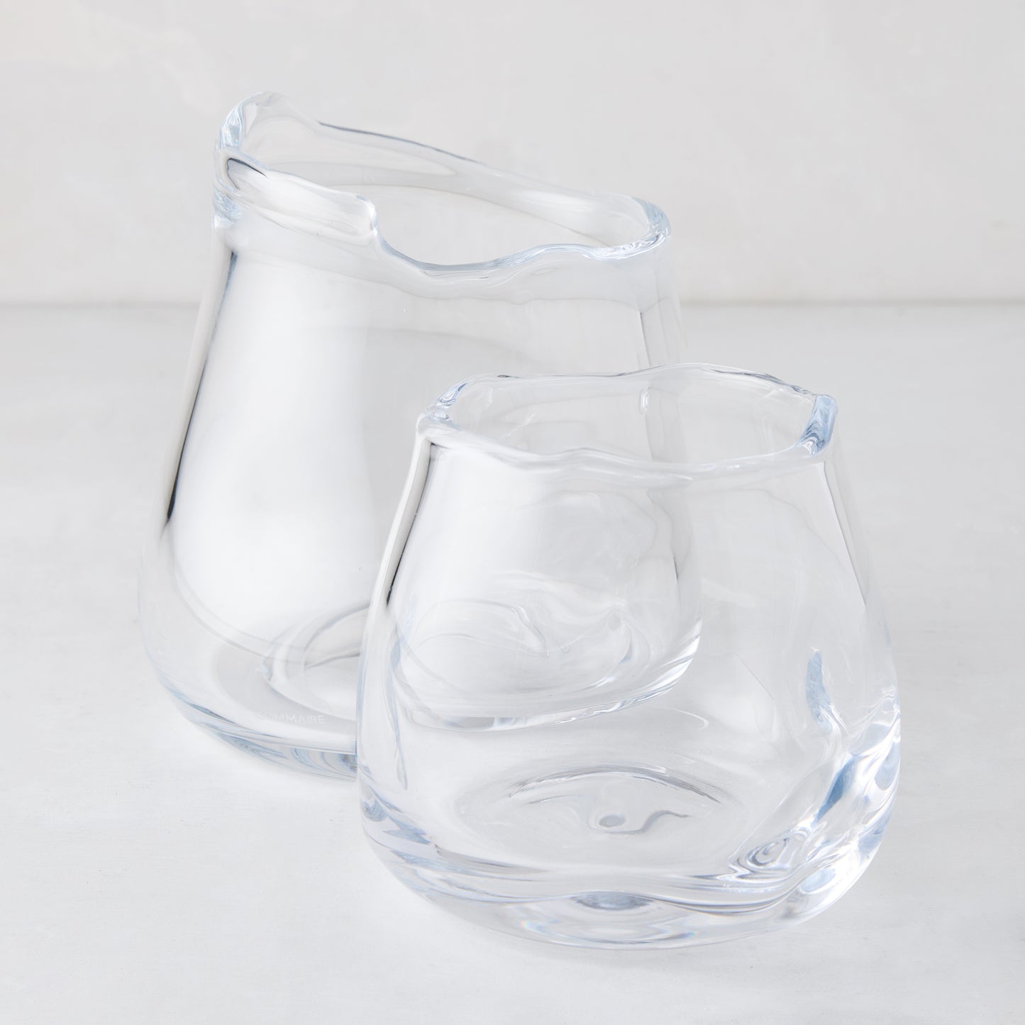 Two clear mouth-blown glass Mia Scissor-Cut Round Vases with unique wavy rims, one larger, one smaller.