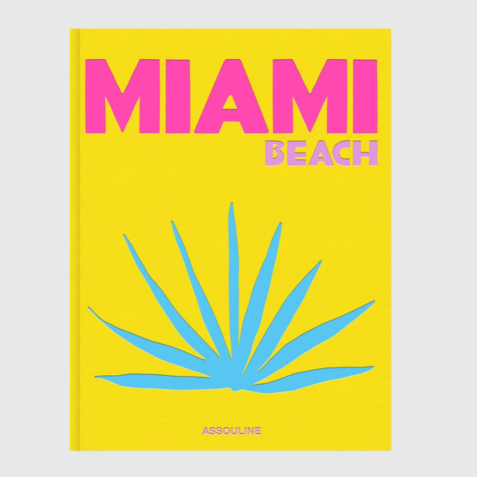 Hudson Grace Miami Beach coffee table book with a bright yellow cover, pink text, and blue palm leaf illustration.