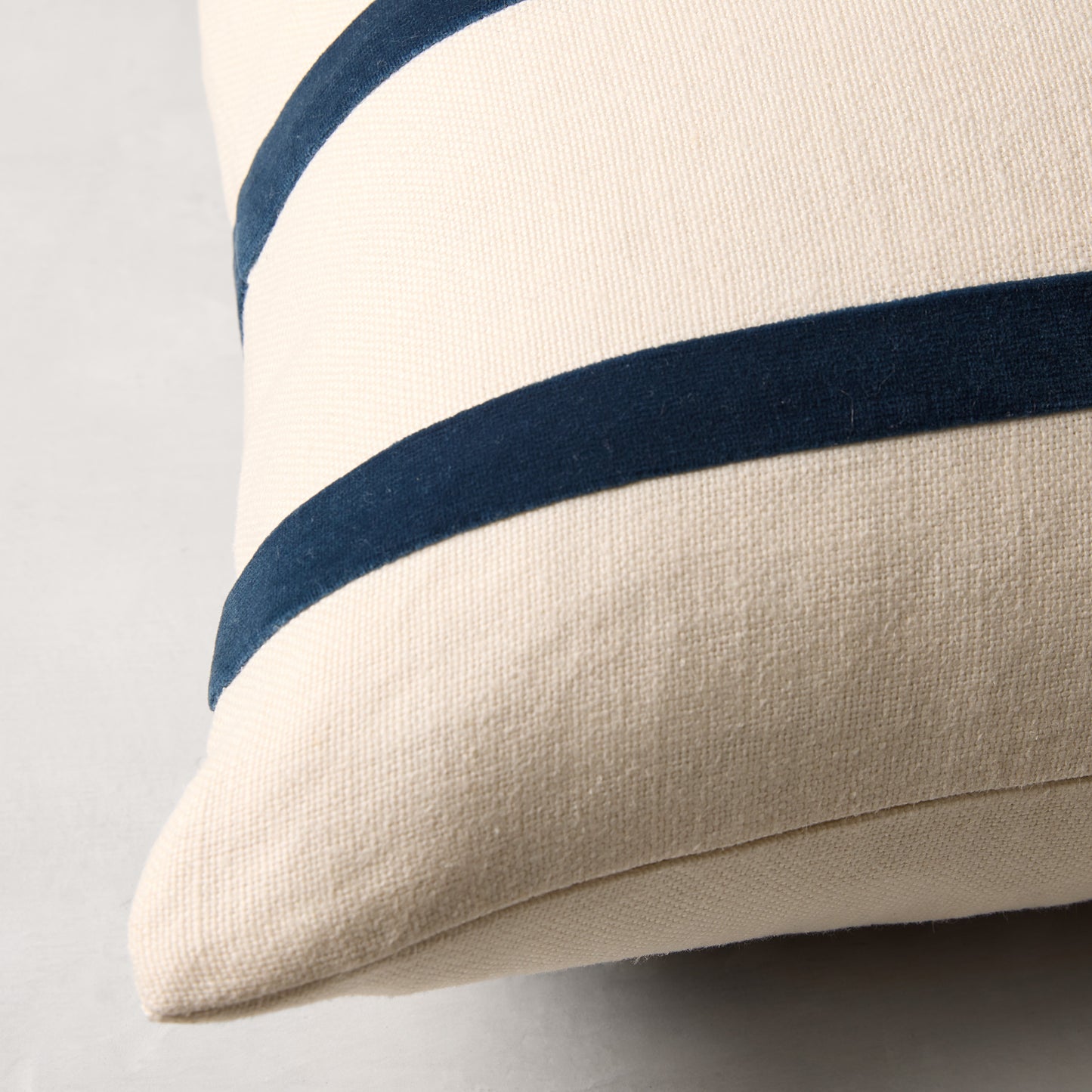 Ivory Belgian Linen pillow with two horizontal Midnight Blue cotton velvet stripes.