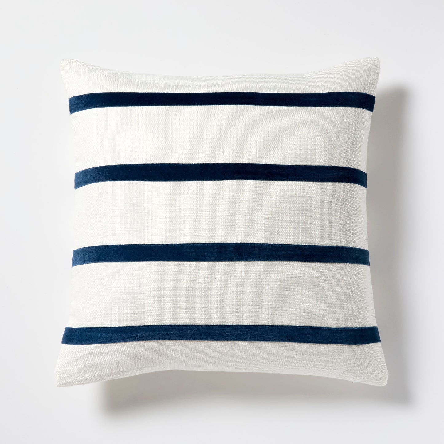 Ivory Belgian Linen pillow with three horizontal Midnight Blue velvet stripes.