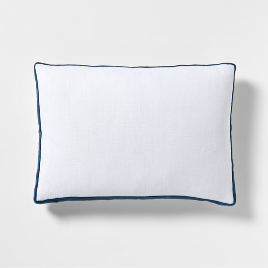 White linen lumbar pillow with midnight blue velvet gusset and piping.