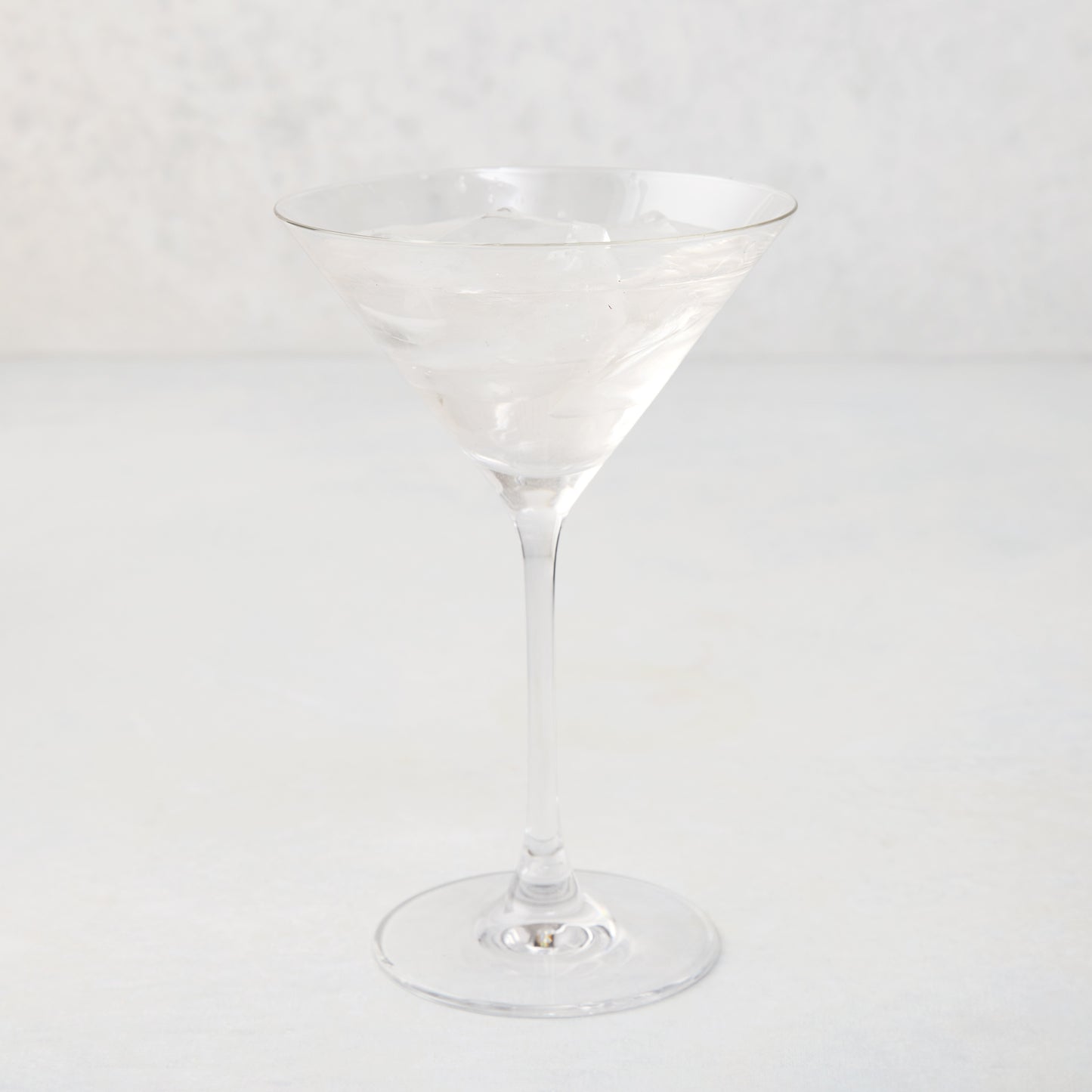 Clear glass Midtown Martini Glass, 8.5"H, filled with ice and a clear drink.