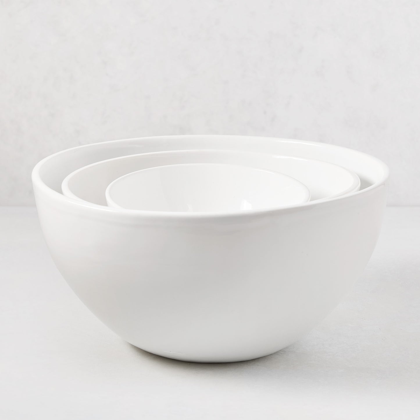 Three nested HG Modern white ceramic serve bowls, medium to small.