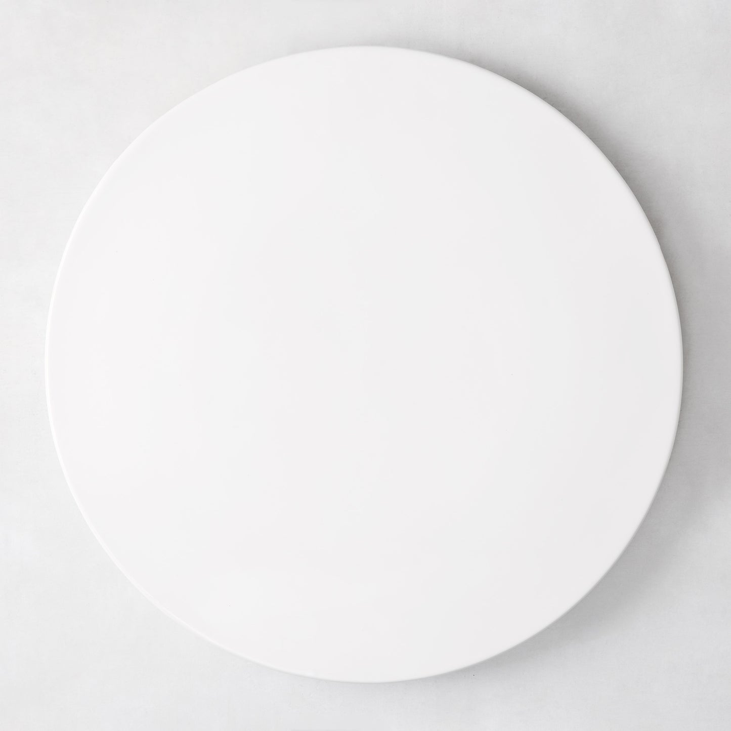 Modern round white ceramic serving platter, 14.5" diameter, smooth edgeless surface.