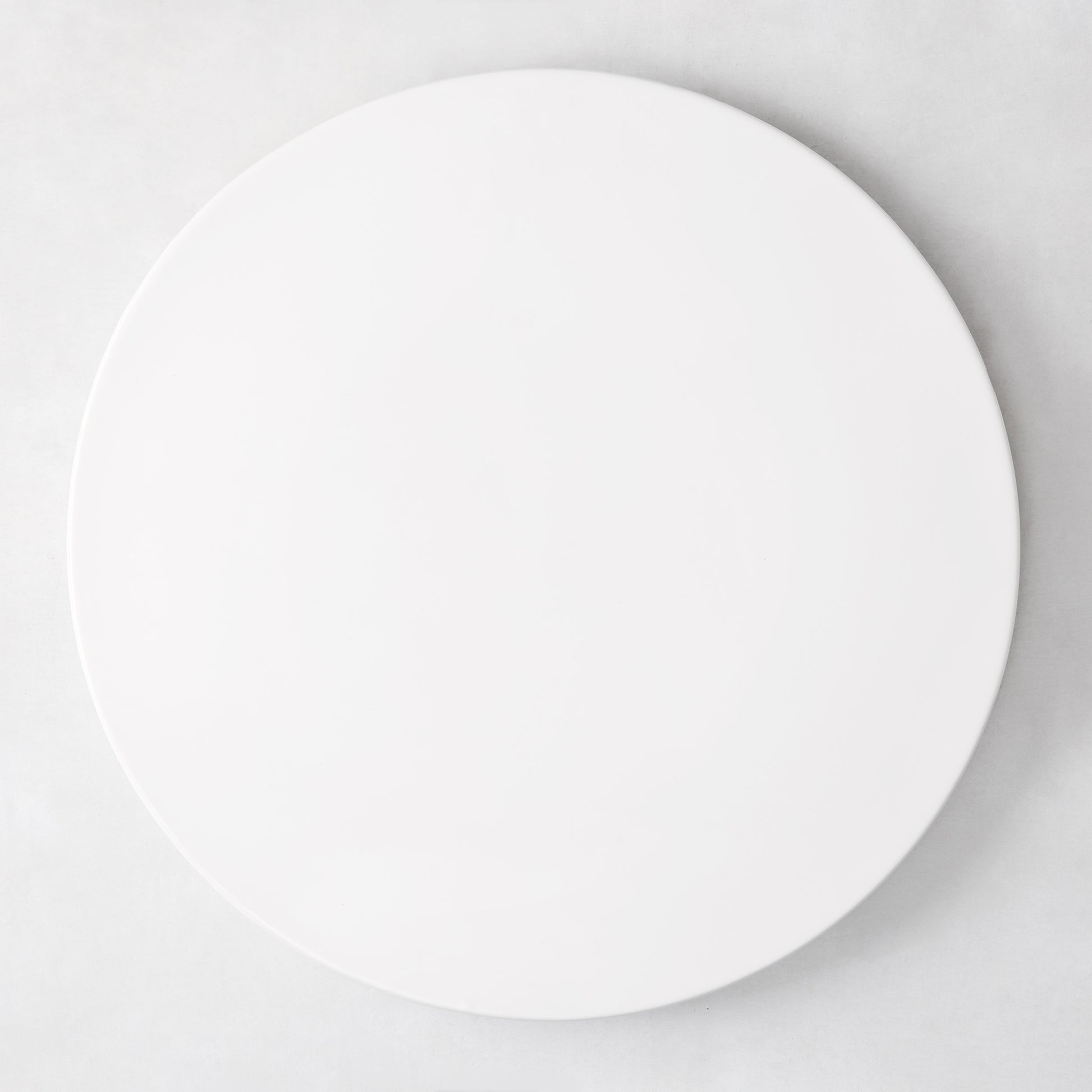 Modern round white ceramic serving platter, 14.5" diameter, smooth edgeless surface.