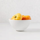 White ceramic HG Modern Small Serve Bowl with yellow and orange heirloom tomatoes.