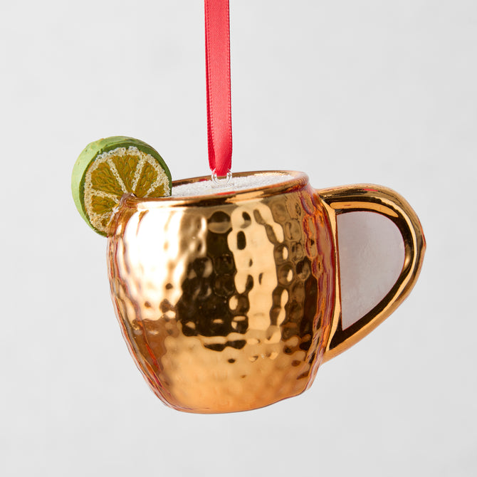 Hand-painted glass Moscow Mule ornament, copper mug with hammered texture, lime slice, red ribbon.
