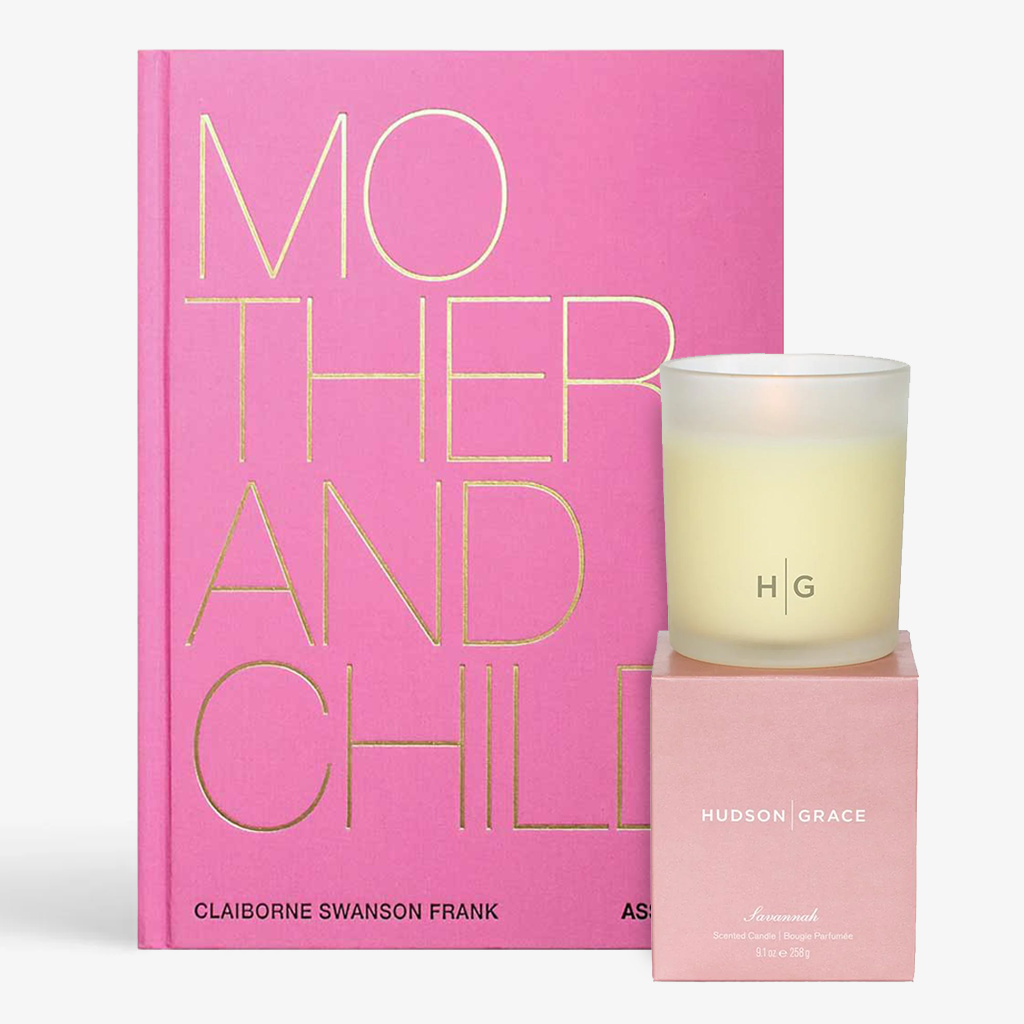 Pink "Mother And Child" book with gold text, beside a lit Savannah candle in a frosted glass holder and pink box.