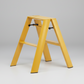Mustard yellow Lucano Hasegawa 2-step lightweight aluminum and steel ladder with black accents.