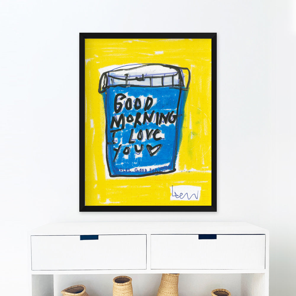 Kerri Rosenthal "My First Love" art print, a blue cup with "Good Morning I Love You" on a yellow background, in a black frame.