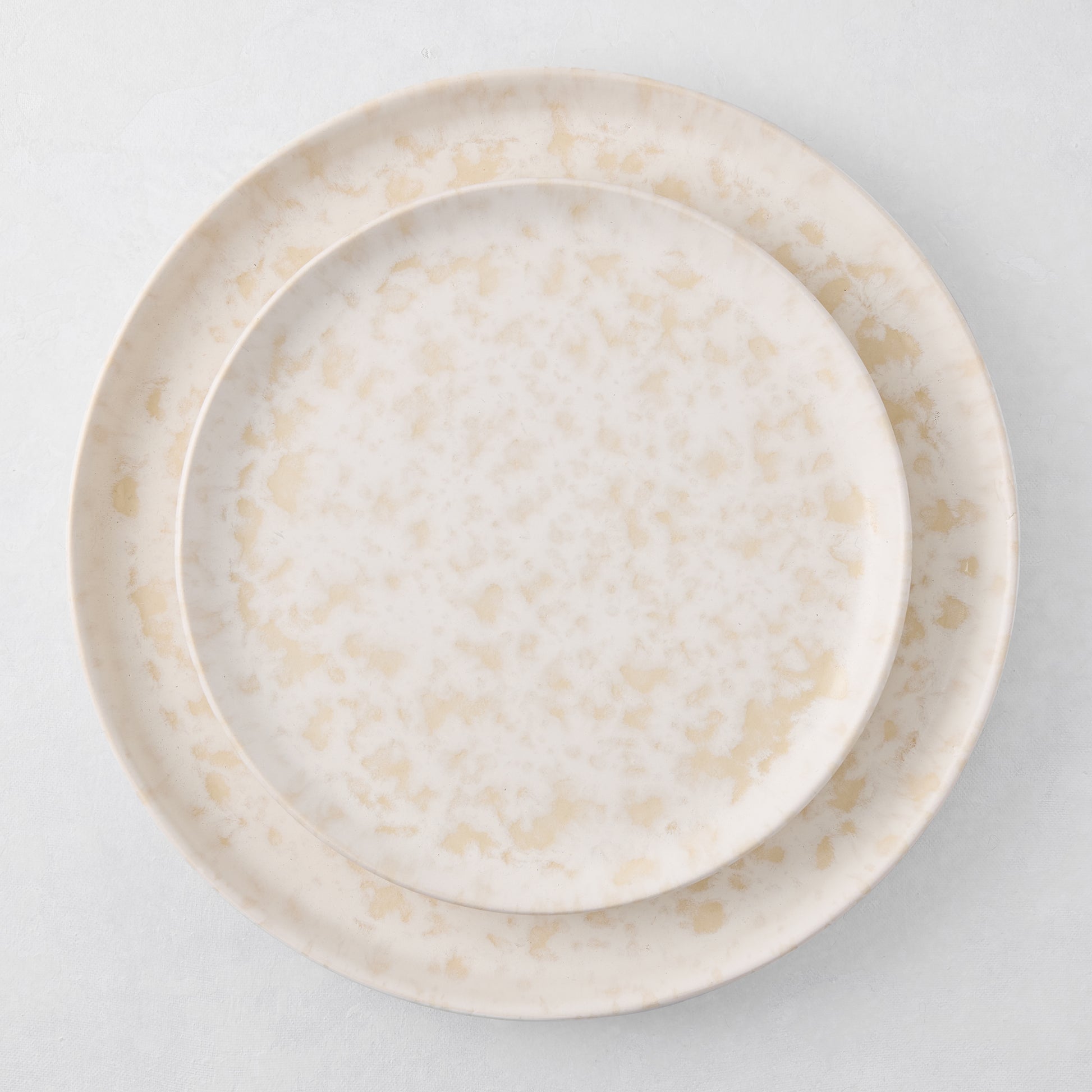 Natural Nuno Splatter 11" stoneware dinner plate with unique beige spots on a pale cream base.