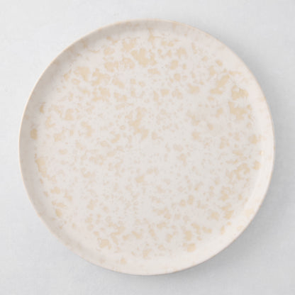 Natural Nuno Splatter 11" stoneware dinner plate with beige spots on a pale cream base.