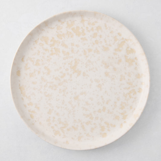 Natural Nuno Splatter 11" stoneware dinner plate with beige spots on a pale cream base.