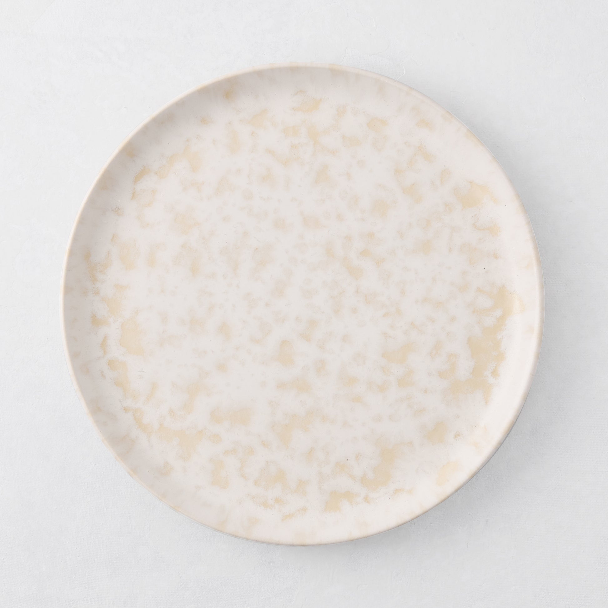 Natural Nuno Splatter 8.25" stoneware salad plate with pale cream base and beige splatter.