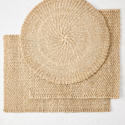 Natural woven abaca square placemat with a round placemat on top, both in a honey-brown hue.