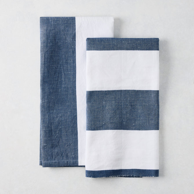 Two navy and white cotton-linen hand towels: one half-navy, half-white; one navy and white striped.