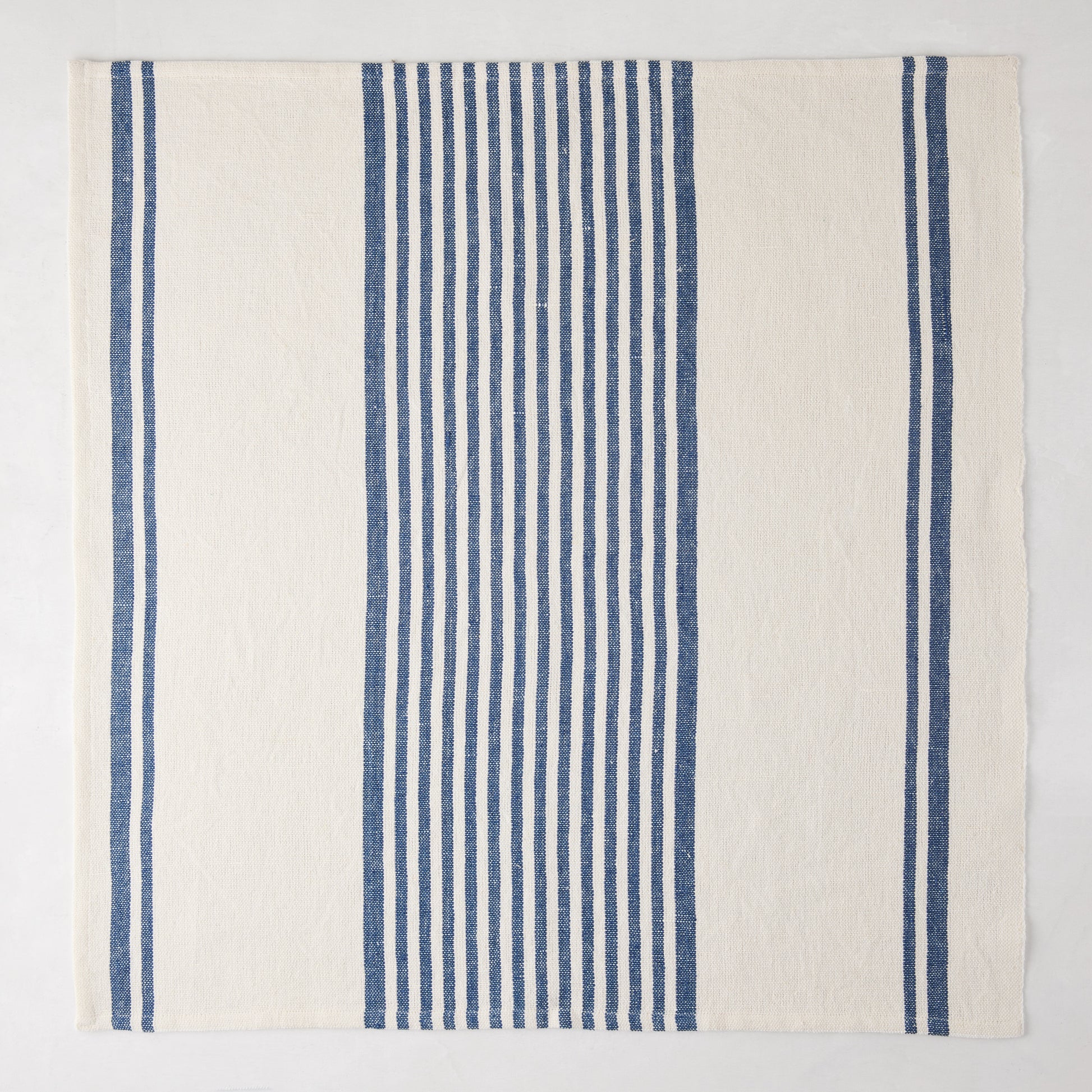 Navy Boat Stripe Napkin, 22" square, woven cotton-linen blend with vertical blue and white stripes.