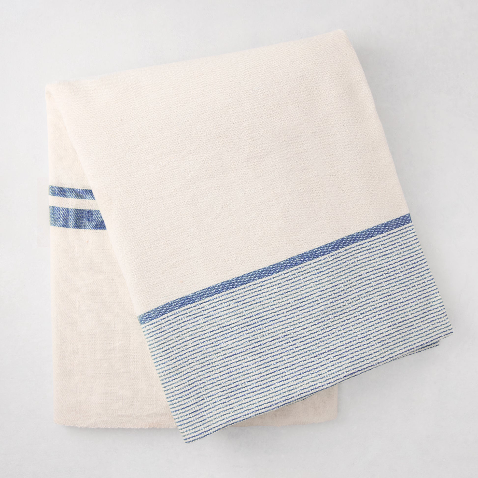 Folded Navy Boat Stripe Tablecloth, 70"x108", cotton-linen blend, with blue horizontal stripes.